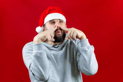 Man wearing hat against red background