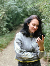 Young woman is walking in the park and talking to her friends with using video call.casual lifestyle