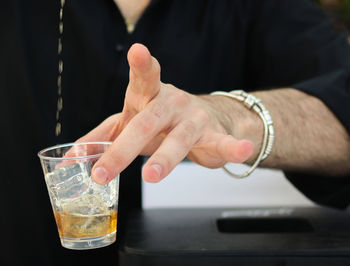 Midsection of man preparing drink