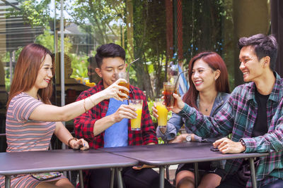 Friends toasting juices at table