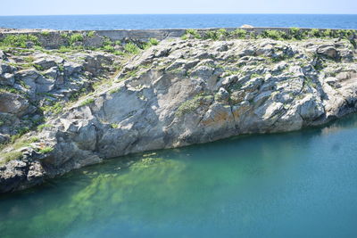 Scenic view of rocks on sea against sky