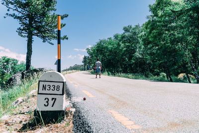 Rear view of road sign against trees