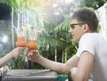 Couple toasting cocktail drinks at poolside