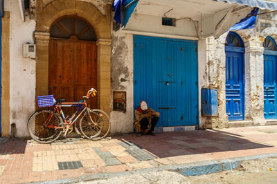 Man with bicycle parked in front of building