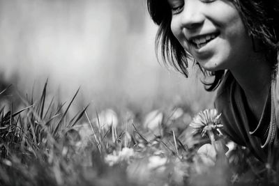 Close-up of young woman with flowers in field