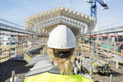 Rear view of female construction worker at site