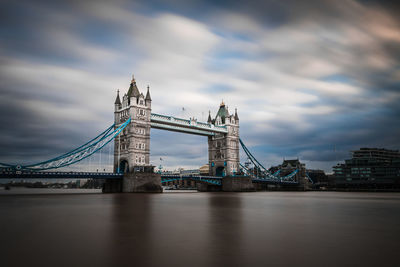 View of bridge over river against cloudy sky