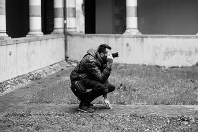 Man photographing by old building