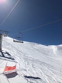 Overhead cable car over snowcapped mountains against sky