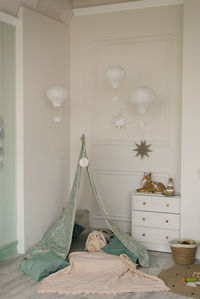 Children's tent tent with pillows and soft bunny toy, white chest of drawers in a modern room 