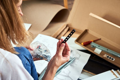 Woman reading manual instruction to assemble furniture