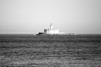 Bugio lighthouse in sea against clear sky