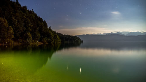 Scenic view of lake against sky at night