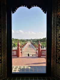 Pathway seen through ornate entrance on sunny day