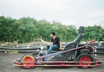 Sports car against man sitting at running track