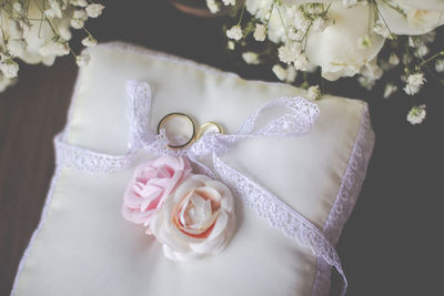Wedding rings with roses on cushion