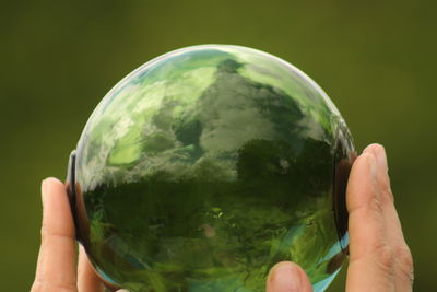 Close-up of hand holding crystal ball