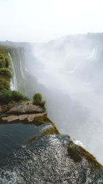 Scenic view of waterfall against sky