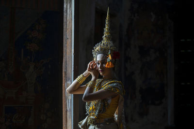 An asian woman wearing a traditional costume for ramya is hidden at the door. suvannamaccha.