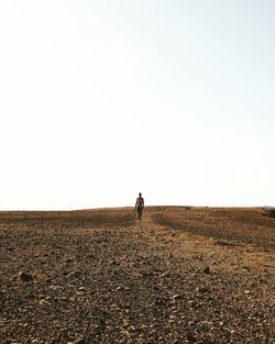 Woman on landscape against clear sky