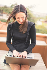 Smiling woman using laptop