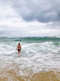 Full length of woman on beach against sky