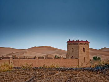 View of building on desert against clear sky