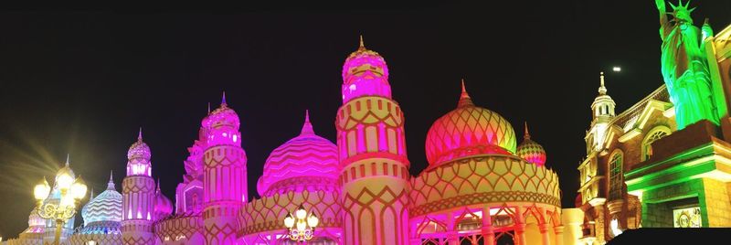 Low angle view of illuminated buildings against sky at night