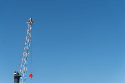 Low angle view of communications tower against blue sky