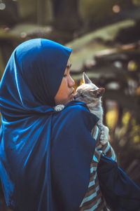 Teenage girl with cat on field