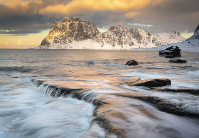 Beautiful sunset on uttakleiv beach at the lofoten in norway. the mountains are covered in snow. 