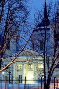 Low angle view of bare trees against built structure