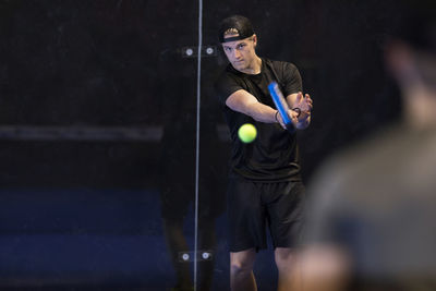 Man playing padel at indoor court