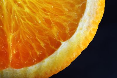Close-up of orange fruit against black background