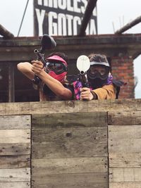 Portrait of friends playing paintball