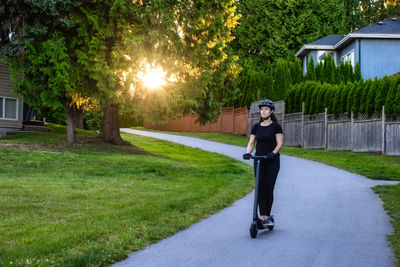 Full length portrait of young woman riding bicycle on road