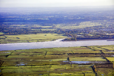 Aerial view of agricultural field in city against sky