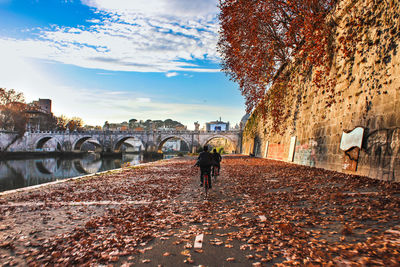 Rear view of woman walking on road during autumn