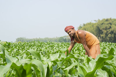 Smiling indian farmer working at agricultural field