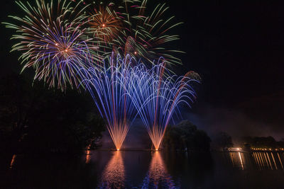 Low angle view of firework display at night