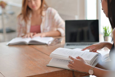 Midsection of woman reading book