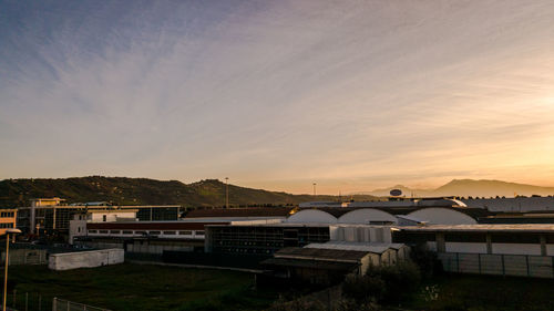 Built structures against sky at sunset