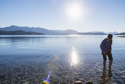 Woman trying the water at nahuel huapi lake in patagonia