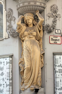 Close-up of gold colored statue against wall