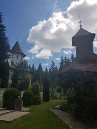 Temple amidst trees and buildings against sky