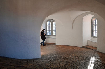 Rear view of woman walking in corridor of building