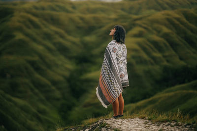 Rear view of woman walking on field