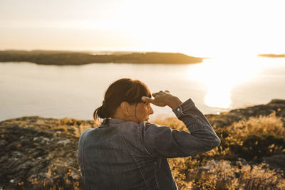 Rear view of man photographing sea against sky