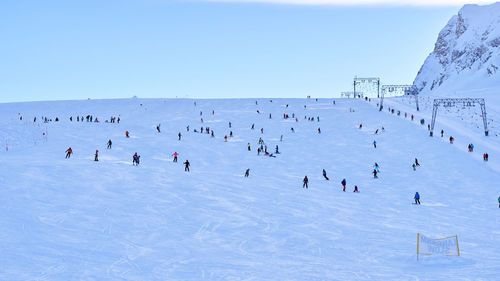 People skiing on snow covered landscape during winter