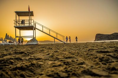 Surface level of lookout tower at beach during sunset